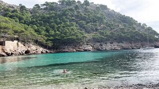 girl swimming on a public beach completely naked