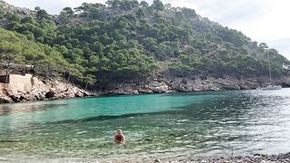 girl swimming on a public beach completely naked