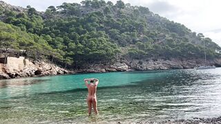 girl swimming on a public beach completely naked