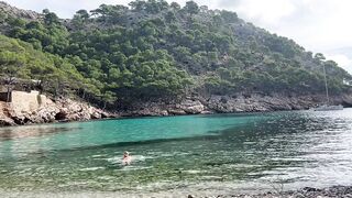 girl swimming on a public beach completely naked