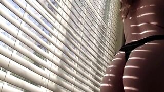 sexy brunette strips and shakes ass for you in front of the window