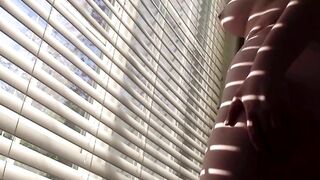 sexy brunette strips and shakes ass for you in front of the window