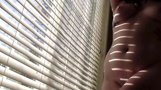 sexy brunette strips and shakes ass for you in front of the window