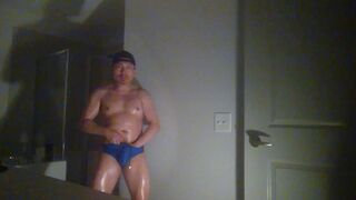 Oiled up and posing while wearing Speedos!