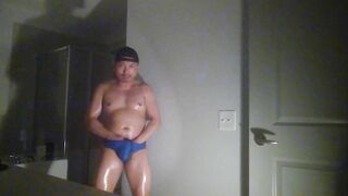 Oiled up and posing while wearing Speedos!