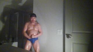 Oiled up and posing while wearing Speedos!